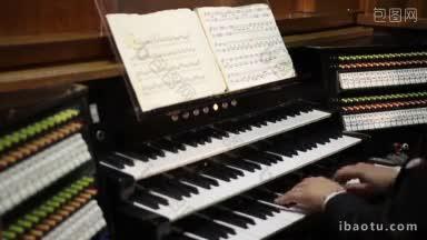 教堂<strong>后景</strong>中，风琴演奏家的手正在弹奏老式键盘和管风琴